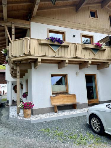 a building with a balcony and a bench in front at Apartment Moosbach in Fieberbrunn