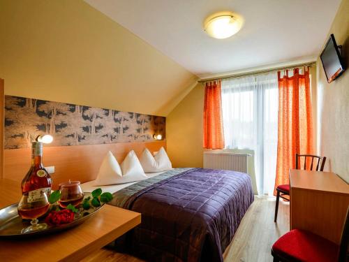 a hotel room with a bed and a table with a bowl of fruit at Ubytovanie pod Tatrami in Nová Lesná