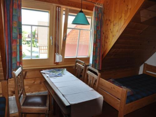 ein Esszimmer mit einem Tisch, Stühlen und einem Fenster in der Unterkunft Pension Schwalbennest in Herdwangen-Schönach