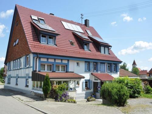una gran casa blanca con techo rojo en Pension Schwalbennest, en Herdwangen-Schönach