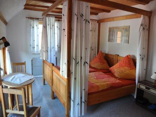 a bedroom with a bed with a wooden frame at Pension Schwalbennest in Herdwangen-Schönach
