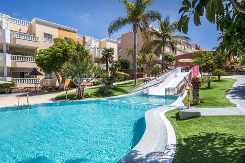 a swimming pool at a resort with palm trees at Allegro Isora in Puerto de Santiago