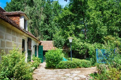 an old house with a garden and a street light at Moulin en Route in Blèves