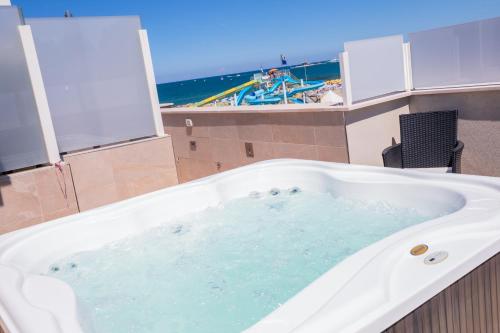 a large bath tub with a view of the beach at Hotel Baby in Rimini