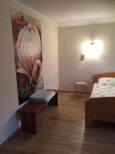 a bedroom with a bed and a painting on the wall at Ferienwohnung-Michels in Orlenbach