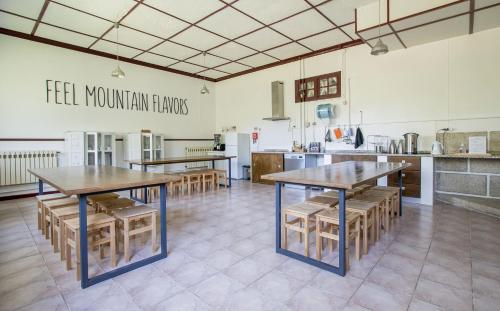 um quarto com mesas e cadeiras numa cozinha em Loriga Hostel - Feel Nature em Longa