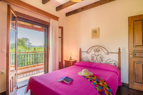 a bedroom with a pink bed and a balcony at Villa Emilia in Sidari