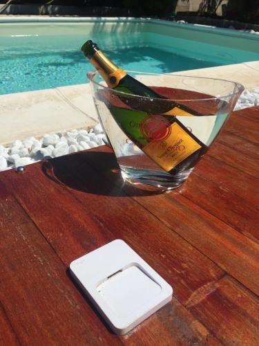 una botella de champán en una mesa junto a la piscina en camera con giardino e piscina, en Scafati