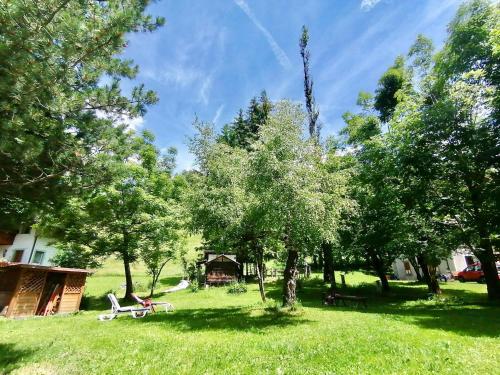 a park with benches and trees and a house at Hotel B&B Lorenzini Ski in Selva di Cadore
