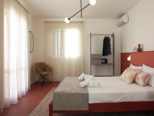 a bedroom with a large bed and a chair at Casa Maja rooms & suites in Favignana