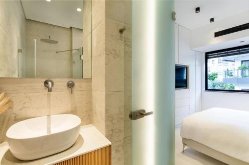 Un baño con lavabo y cama. en Luxury & Quiet 2BDR near Gordon Beach, en Tel Aviv