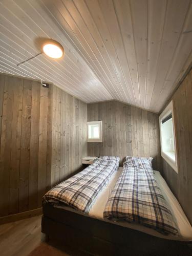 a bedroom with a bed in a room with wooden walls at Villa Solsiden Geilo in Geilo