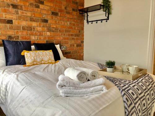 a bedroom with a bed with towels on it at NG1 Lofts in Nottingham