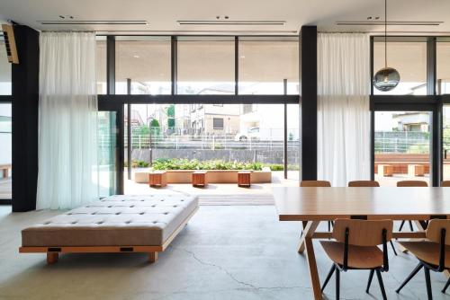 東京にあるMUSTARD HOTEL SHIMOKITAZAWAのテーブルとベンチ付きの広い客室です。