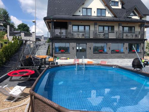 a house with a swimming pool in front of a house at Baranek in Czerwienne