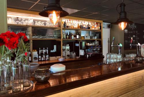 un bar con un mostrador con jarrones y botellas en Hotel Molengroet, en Noord-Scharwoude