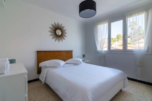 Un dormitorio blanco con una cama blanca y una ventana. en C078-Superb apt in Cannes - Sea view - 6 people, en Cannes
