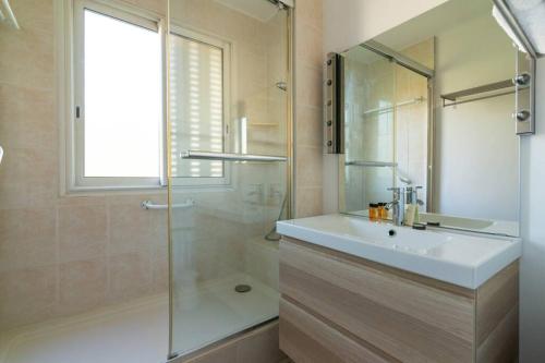 Un baño con lavabo y ducha de cristal. en C078-Superb apt in Cannes - Sea view - 6 people, en Cannes