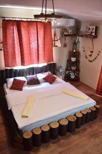 a large bed in a bedroom with red curtains at HANI I VJETER Boutique Hotel in Prizren