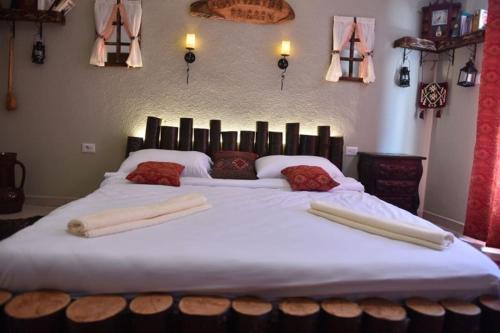 ein großes Bett mit weißer Bettwäsche und Kissen darauf in der Unterkunft HANI I VJETER Boutique Hotel in Prizren