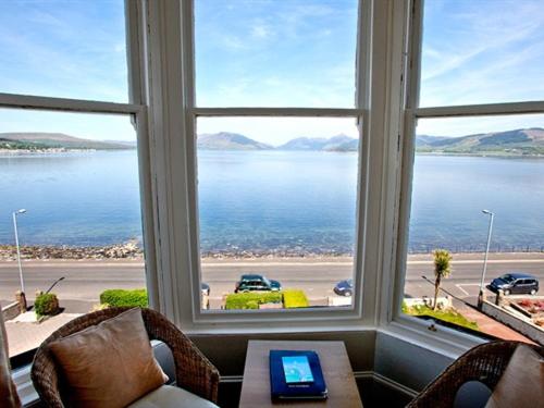 a room with a large window with a view of the ocean at The Ardyne Guest House in Rothesay