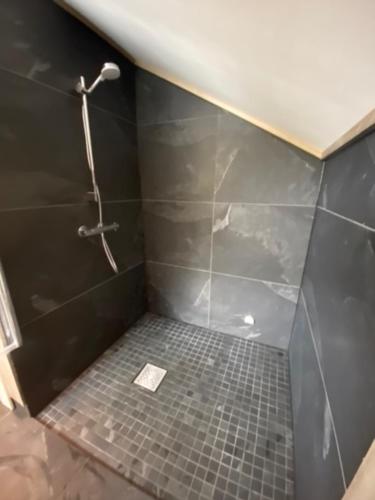 a bathroom with a shower with a tiled floor at Villa Solsiden Geilo in Geilo