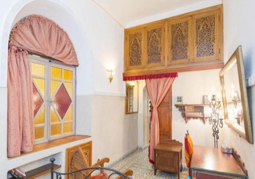Riad Maison Arabo-Andalouse في مراكش: غرفة طعام مع طاولة ونافذة