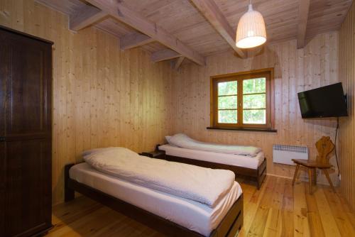 a bedroom with two beds and a tv in it at Domek na Stoku in Kazimierz Dolny