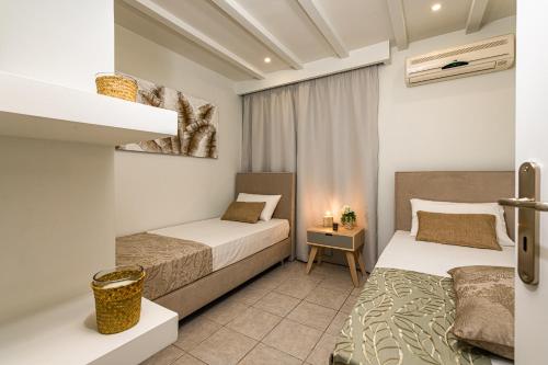 ヴァシリコスにあるTortuga Dafni Bay Villas Diver's Paradiseのベッドルーム1室(ベッド2台、ナイトスタンド付)