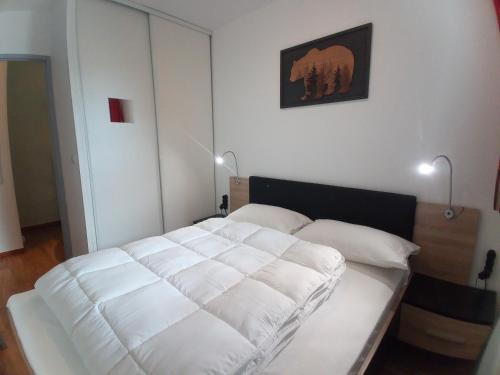 1 cama blanca en una habitación con 2 lámparas en Au bon endroit N2 - Appartement 2 pièces 7 personnes - proche pistes - Belle vue, en Orcières
