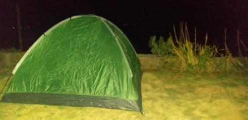 a green tent sitting in a field at night at Amantani Lodge in Amantani