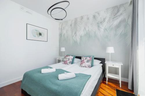 a bedroom with a bed with two towels on it at Apartment Łobzowska Cracow by Noclegi Renters in Kraków