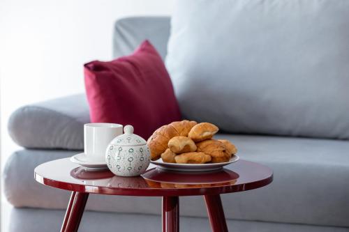 a table with a plate of pastries and a cup of coffee at Apartment Łobzowska Cracow by Noclegi Renters in Kraków