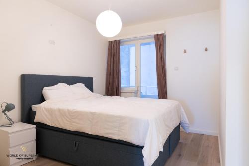 um quarto com uma cama grande e uma janela em Hélène, appartement vlakbij het strand em Oostende