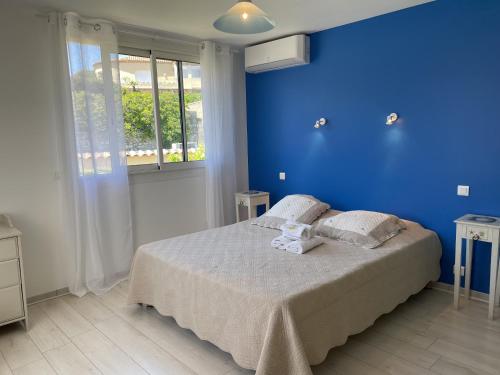 a blue bedroom with a bed with towels on it at "Cap Riviera" Hotel & Restaurant Saint Aygulf in Saint-Aygulf