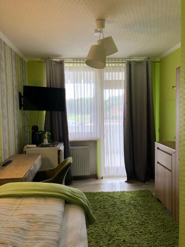 a bedroom with green walls and a bed with a green rug at Pension Ottenheide in Schloß Holte-Stukenbrock