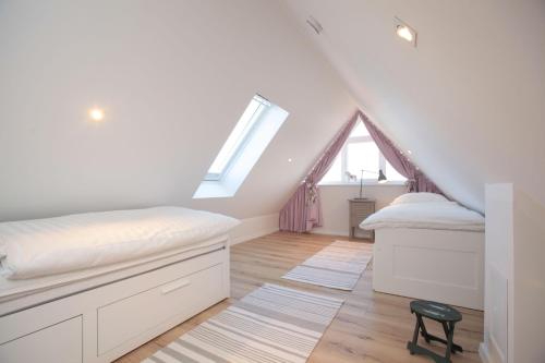 - une chambre mansardée avec 2 lits et une fenêtre dans l'établissement Bootshaus-am-Strand-Wohnung-4, à Wangerooge