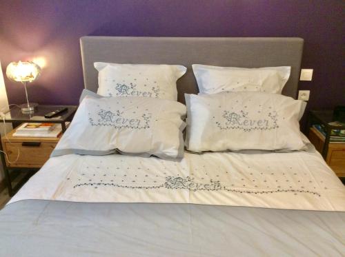 ein Bett mit weißer Bettwäsche und weißen Kissen in der Unterkunft Chambre tout confort du Tilleul in Bosc-Bénard-Commin