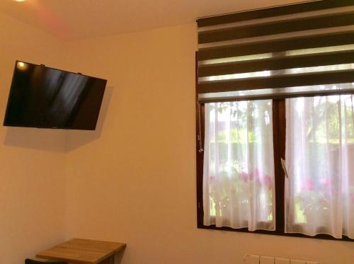 Televízia a/alebo spoločenská miestnosť v ubytovaní Chambre tout confort du Tilleul