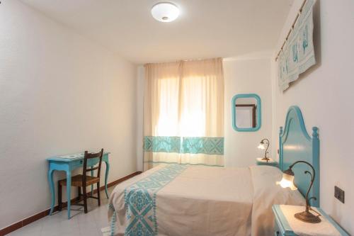 1 dormitorio con cama, mesa y ventana en Piccola casa Marina, en Villa San Pietro