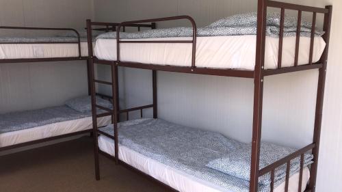 GLAMTAINER COURT في Curteni: سريرين بطابقين في غرفة نوم مع
