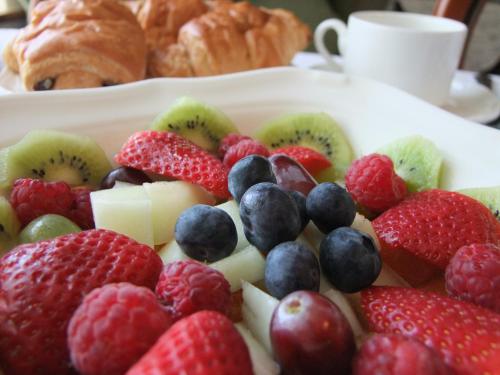 un plato de fruta en una mesa con bollería y cruasanes en Erw-Lon Farm en Pontfaen