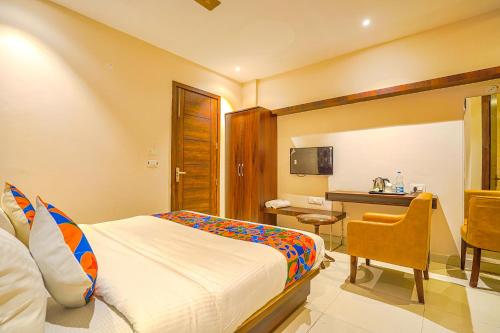 a hotel room with a bed and a desk at FabHotel Prime Empire in Amritsar
