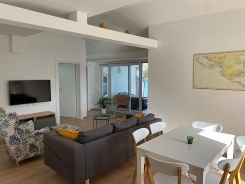 uma sala de estar com um sofá e uma mesa em Apartments Vala em Grebaštica