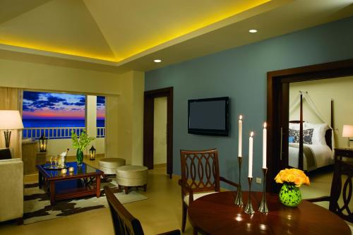 a living room filled with furniture and a tv at Secrets St. James in Montego Bay