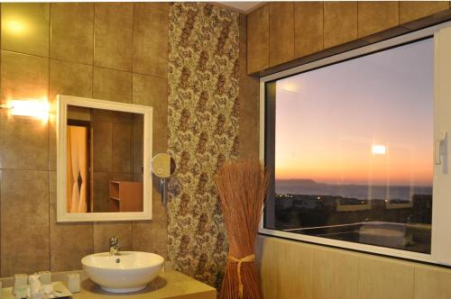 ein Badezimmer mit einem Waschbecken und einem großen Fenster in der Unterkunft Chersonissos Villa Elite in Hersonissos
