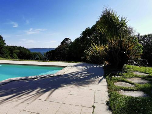 a sidewalk next to a swimming pool with palm trees at Domaine de Stang Bihan in Concarneau