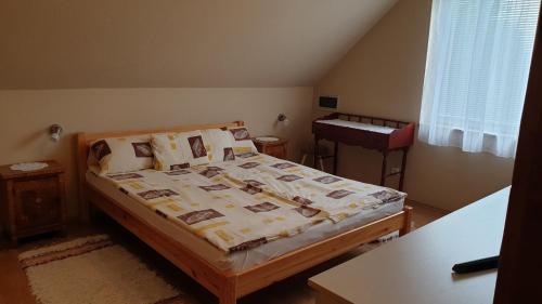 a bedroom with a bed and a table and a window at Ilona apartmanok in Balatonboglár