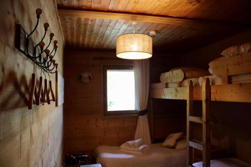 Cette chambre comprend deux lits superposés et une lampe. dans l'établissement Chalet Le Bouton D'or, à Les Deux Alpes