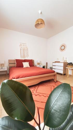 a bedroom with a red bed with a green plant at La Araucania, 2 personnes - WIFI in Rombach-le-Franc